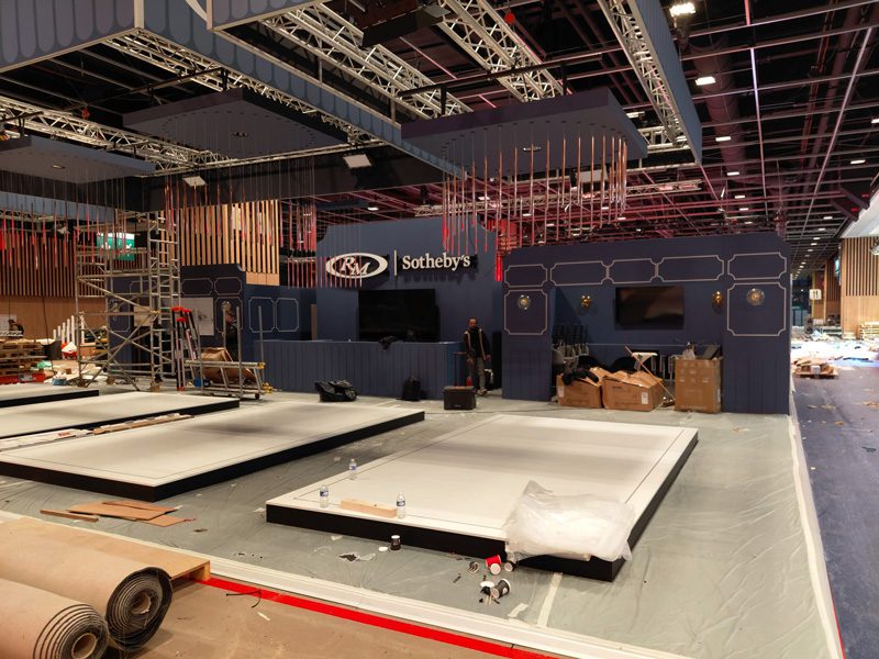 Podiums d’exposition des voitures Sotheby’s habillés par Baseline Production avec adhésif miroir et bordures en adhésif noir mat au salon Rétromobile Paris.