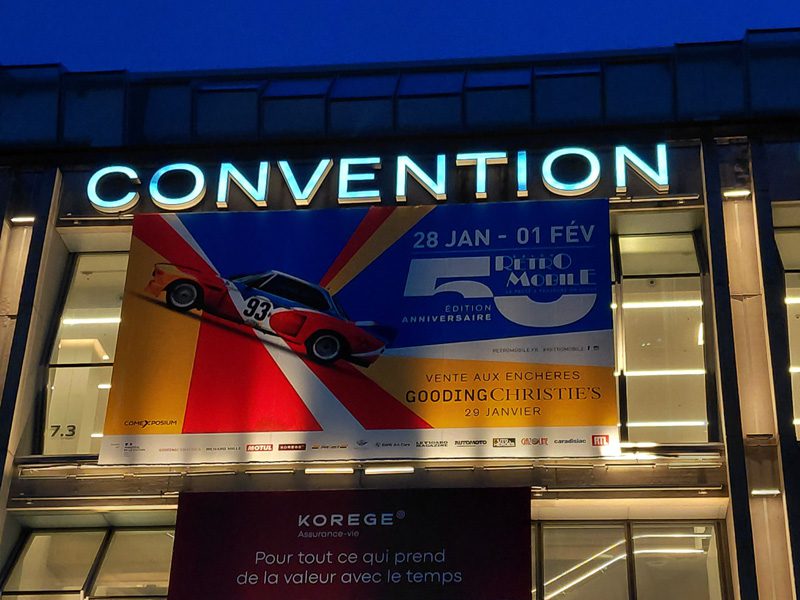 Podiums d’exposition des voitures Sotheby’s habillés par Baseline Production avec adhésif miroir et bordures en adhésif noir mat au salon Rétromobile Paris.